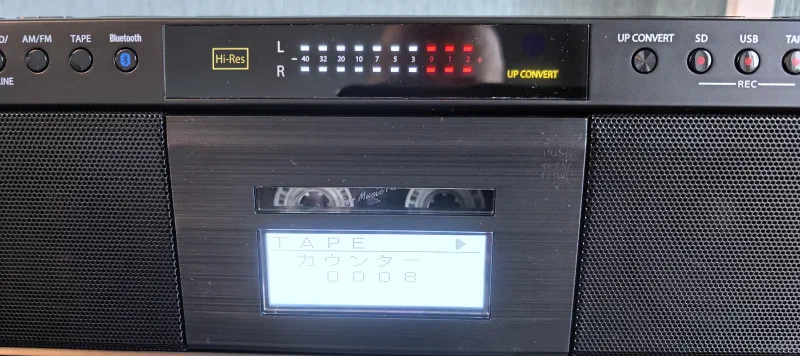 Кассета играет, дисплей показывает уровни сигнала и режим TAPE