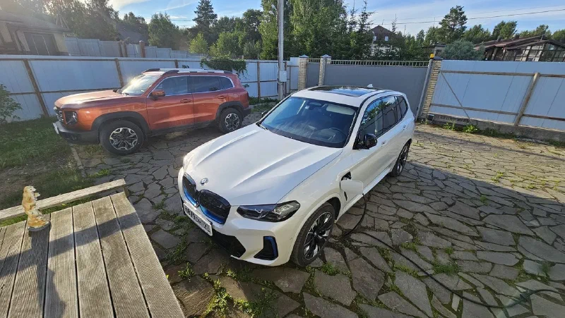 BMW iX3 дома на зарядке, рядом стоит Dargo, такой вот раздельный гибрид получился
